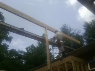 Carpenter setting a ridge beam over a new addition frame — Ice Dam Removal by Roofing Brothers in Pleasant Shade