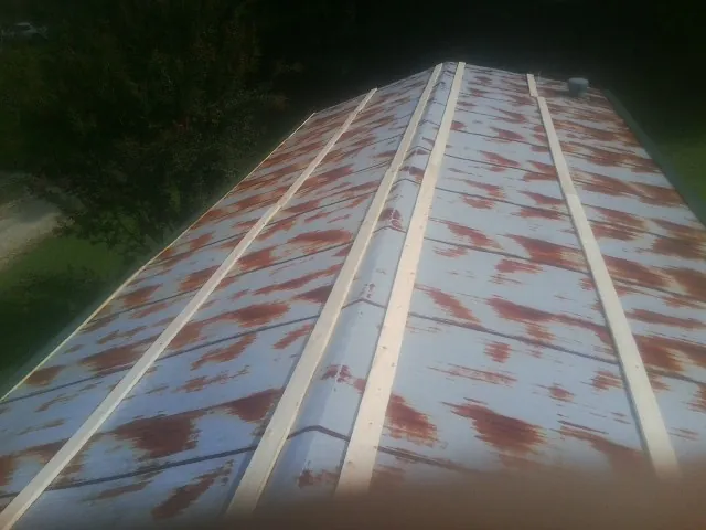 Rusted metal roof panels with new wood purlins before replacement — Storm Damage Roof Repair in Pleasant Shade by Roofing Brothers